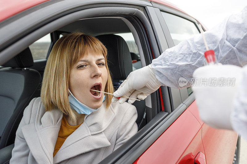 坐在车里接受COVID - 19病毒检测的妇女
